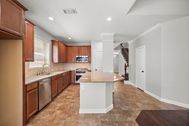 kitchen featuring tasteful backsplash, visible vents, a center island, a sink, and stainless steel appliances