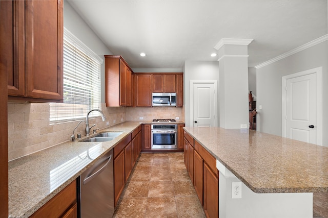 kitchen featuring light stone countertops, a center island, appliances with stainless steel finishes, a sink, and backsplash