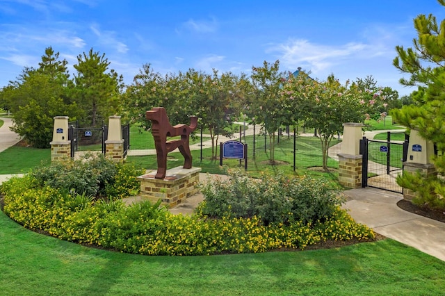 surrounding community with fence, a gate, and a lawn
