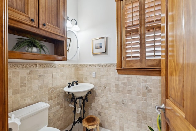 6114 Truro St, Houston, TX 77007 - bathroom featuring toilet, a sink, a wainscoted wall, and tile walls