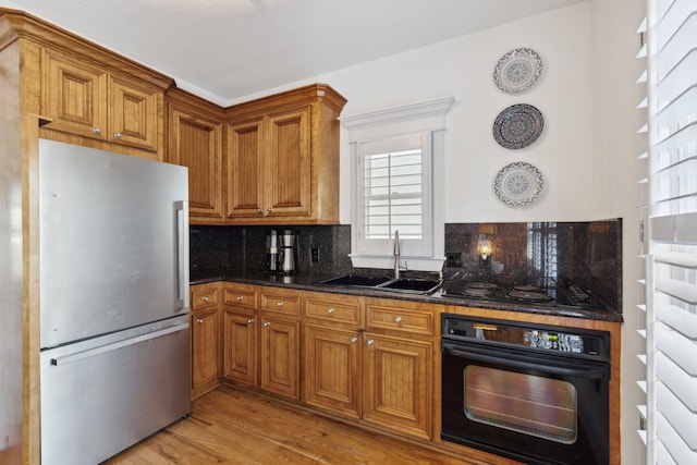6114 Truro St, Houston, TX 77007 - kitchen featuring a sink, backsplash, freestanding refrigerator, and black oven