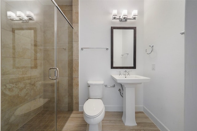 full bath featuring toilet, a shower stall, wood finished floors, and baseboards