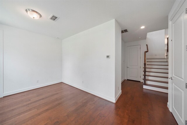 empty room featuring wood finished floors, visible vents, and baseboards