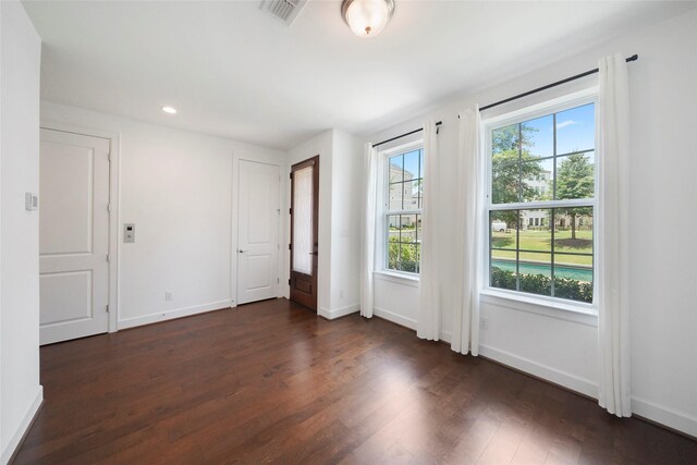 interior space with baseboards, visible vents, dark wood-type flooring, and recessed lighting