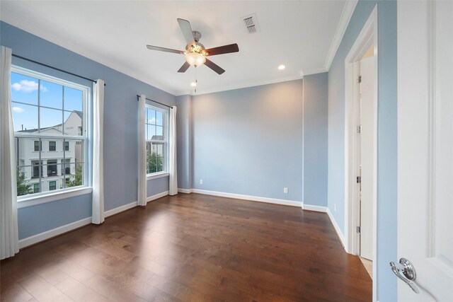 spare room with wood finished floors, ceiling fan, ornamental molding, and baseboards