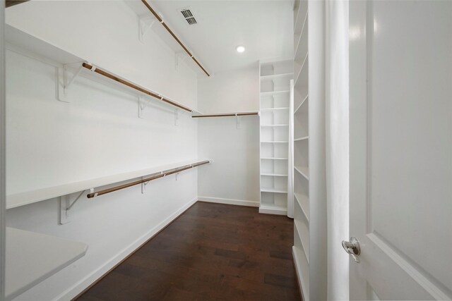 spacious closet with dark wood-style flooring and visible vents