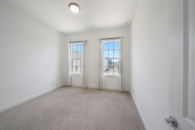 empty room with baseboards and light carpet