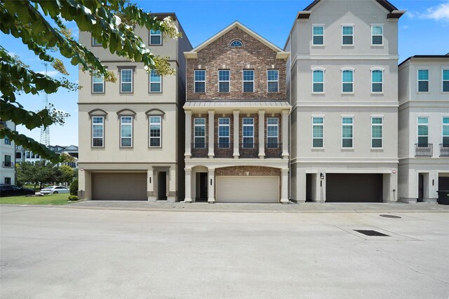 multi unit property featuring a garage, stucco siding, and driveway