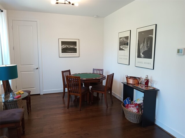 dining space with dark wood finished floors and baseboards