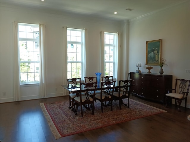 dining room with crown molding, visible vents, wood finished floors, and plenty of natural light