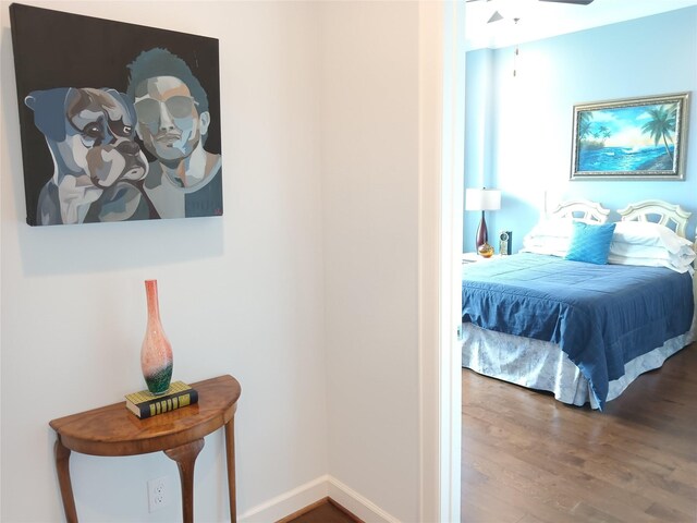 bedroom featuring baseboards and wood finished floors