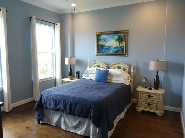 bedroom featuring crown molding, wood finished floors, and baseboards