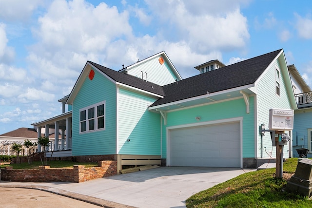 view of side of property featuring roof with shingles, an attached garage, and driveway