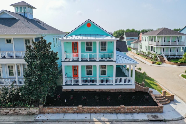 view of front facade featuring a porch, a standing seam roof, and metal roof