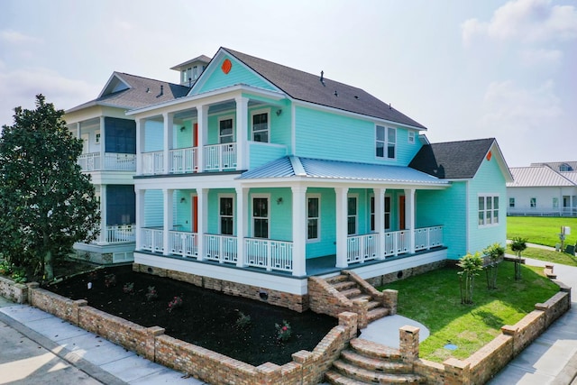 13 Caravelle Ct, Galveston, TX 77554 - view of front of property with a porch, a front yard, and a shingled roof