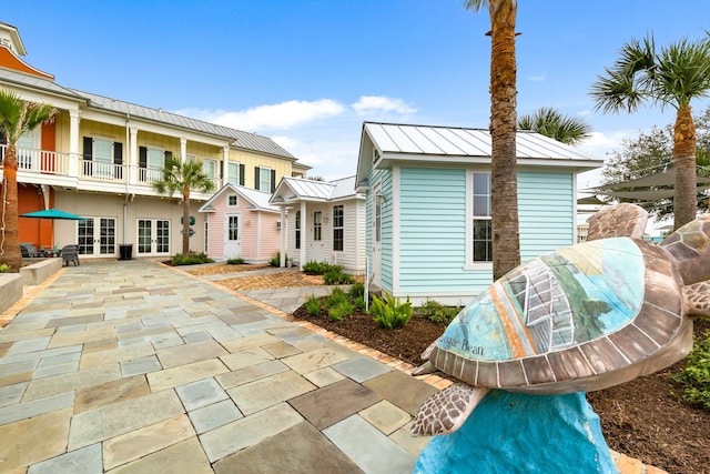 exterior space with french doors, a standing seam roof, and metal roof