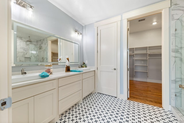 13 Caravelle Ct, Galveston, TX 77554 - bathroom featuring a marble finish shower, a spacious closet, and double vanity