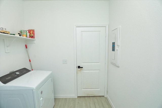 17014 Wild Stream Ct, Conroe, TX 77302 - washroom with laundry area, light wood-style flooring, washer / dryer, electric panel, and baseboards