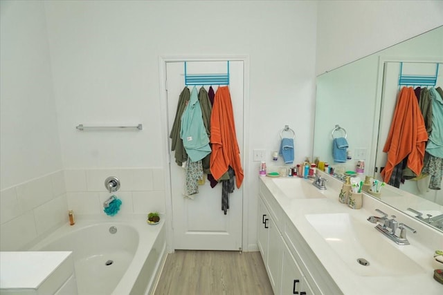 17014 Wild Stream Ct, Conroe, TX 77302 - full bath featuring a garden tub, double vanity, a sink, and wood finished floors