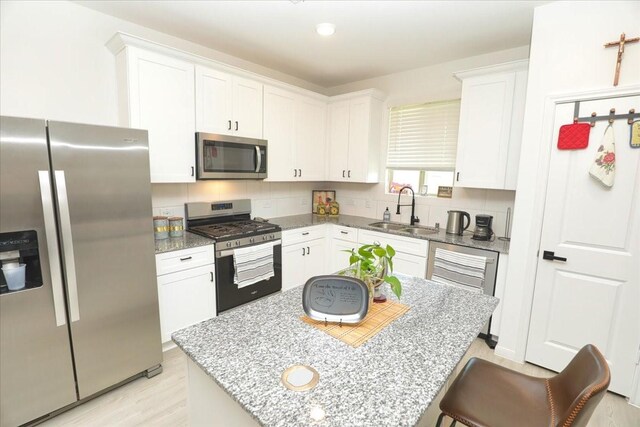 17014 Wild Stream Ct, Conroe, TX 77302 - kitchen featuring white cabinets, light stone counters, appliances with stainless steel finishes, and a sink