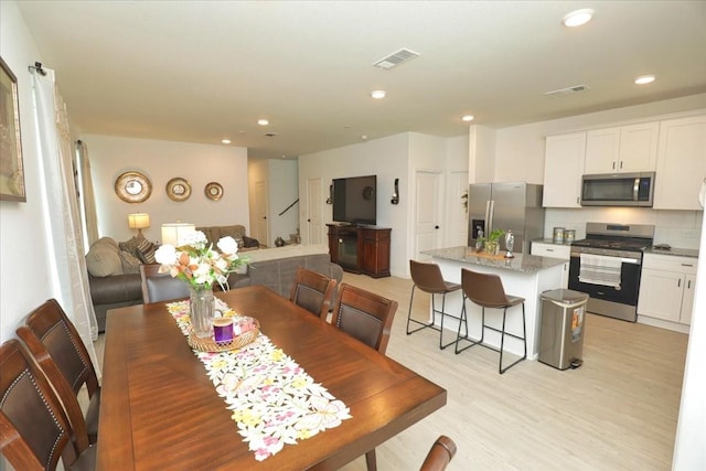 17014 Wild Stream Ct, Conroe, TX 77302 - dining space featuring visible vents, light wood finished floors, and recessed lighting