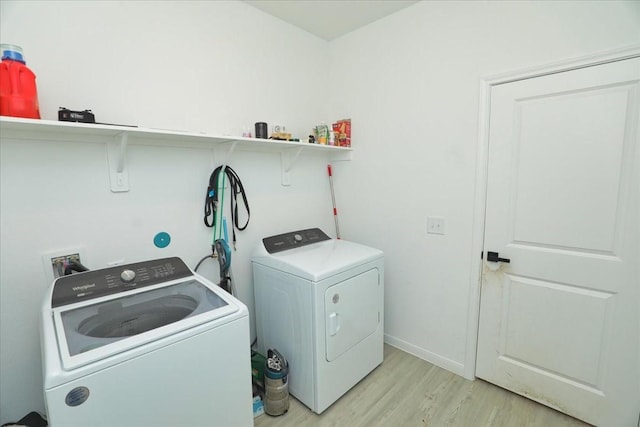 17014 Wild Stream Ct, Conroe, TX 77302 - laundry area with light wood-type flooring, baseboards, laundry area, and washing machine and dryer