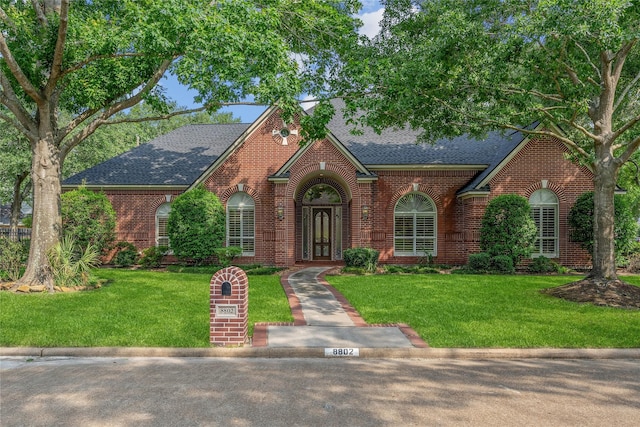 8802 Kennet Valley Rd, Spring, TX 77379 - view of front facade with brick siding, roof with shingles, and a front yard
