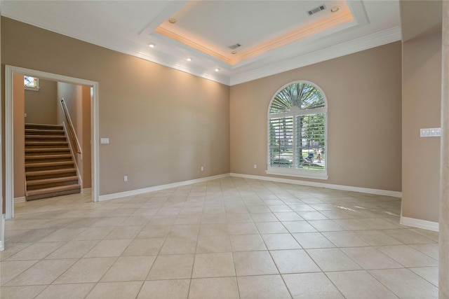 8802 Kennet Valley Rd, Spring, TX 77379 - empty room with crown molding, stairs, a raised ceiling, light tile patterned floors, and baseboards
