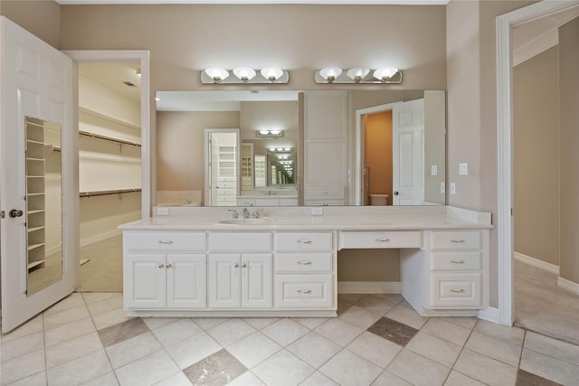8802 Kennet Valley Rd, Spring, TX 77379 - bathroom with vanity, a walk in closet, tile patterned floors, and baseboards