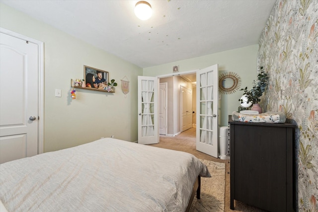 carpeted bedroom featuring baseboards and french doors