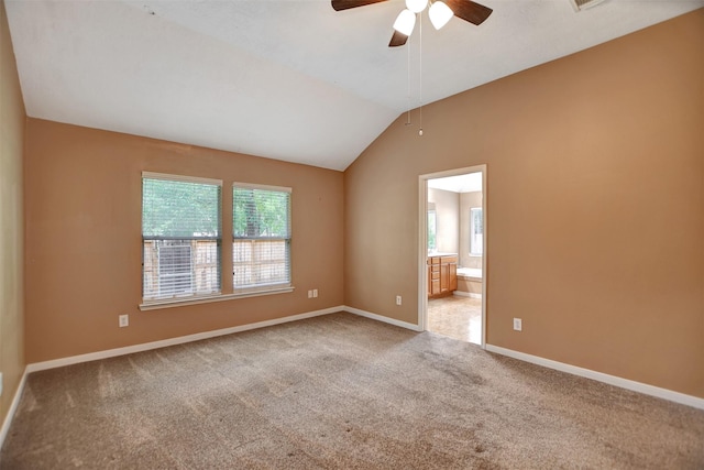 carpeted spare room with ceiling fan, baseboards, and lofted ceiling