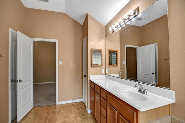 bathroom with vanity, baseboards, lofted ceiling, and visible vents