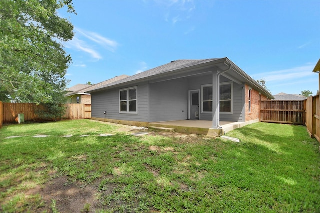 back of property with a patio, a fenced backyard, a yard, and brick siding