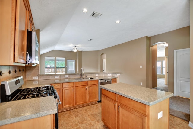 kitchen with visible vents, a sink, ceiling fan, arched walkways, and appliances with stainless steel finishes