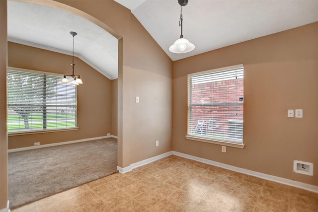 empty room featuring baseboards, light carpet, vaulted ceiling, and arched walkways