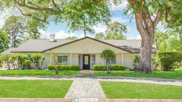14227 Indian Wells Dr, Houston, TX 77069 - view of front facade featuring a front yard, a chimney, and brick siding