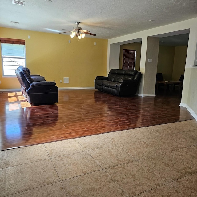 11727 Madison Oak St, Houston, TX 77038 - living room with visible vents, a textured ceiling, baseboards, and wood finished floors