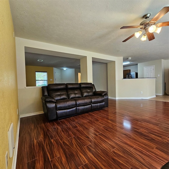 11727 Madison Oak St, Houston, TX 77038 - living room with baseboards, a textured ceiling, visible vents, ceiling fan, and wood finished floors