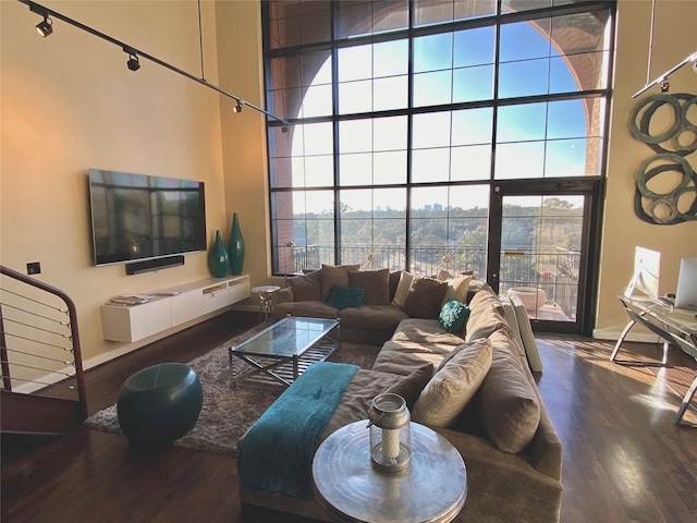 living room with a high ceiling and wood finished floors