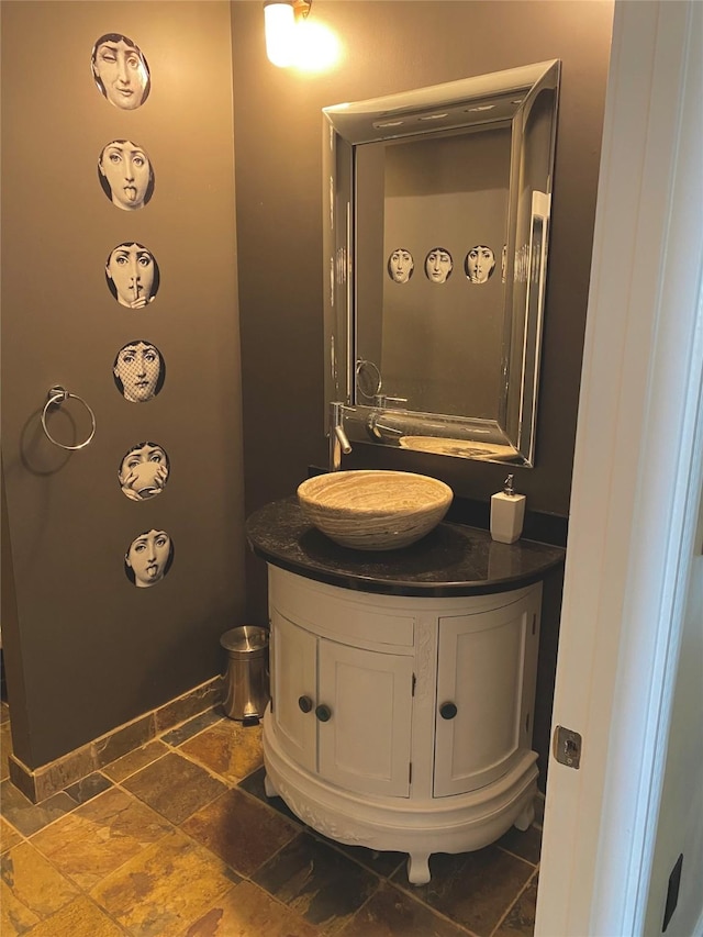 bathroom with stone tile floors and vanity