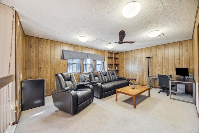 living room featuring wood walls, a textured ceiling, and carpet floors