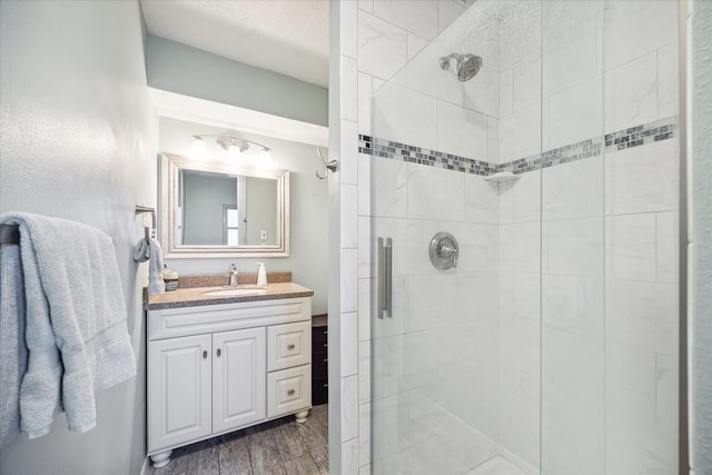 full bath with a stall shower, wood finished floors, and vanity