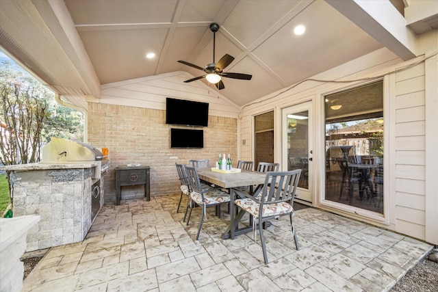 view of patio / terrace with outdoor dining space, a ceiling fan, and an outdoor kitchen