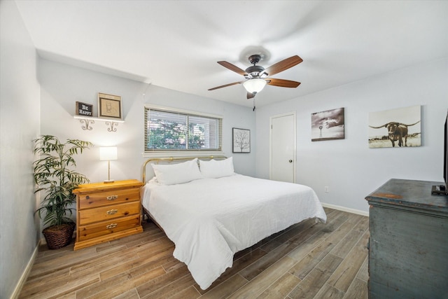 bedroom with wood finished floors, a ceiling fan, and baseboards