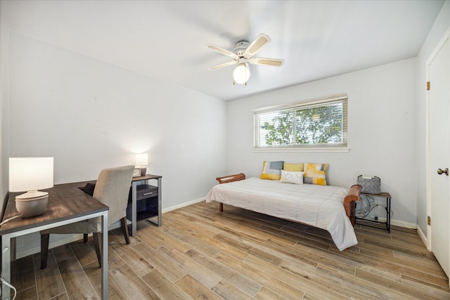 bedroom with light wood-style floors, a ceiling fan, and baseboards