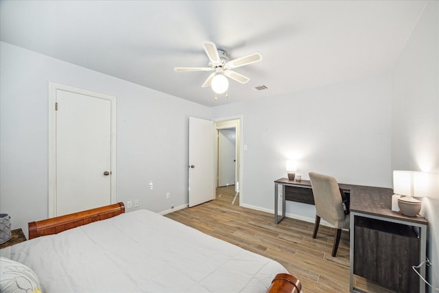 bedroom with a ceiling fan, visible vents, light wood-style flooring, and baseboards