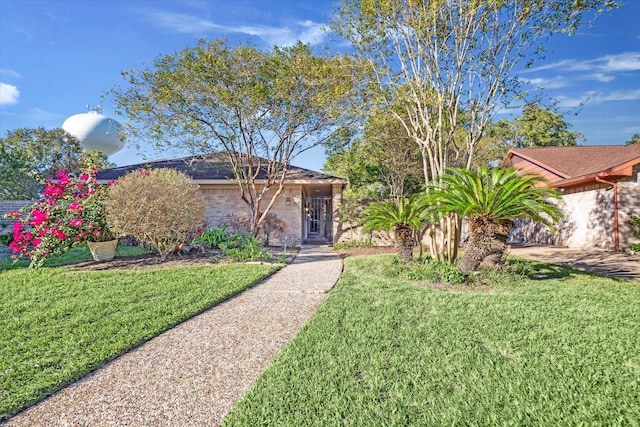 single story home featuring a front lawn and brick siding