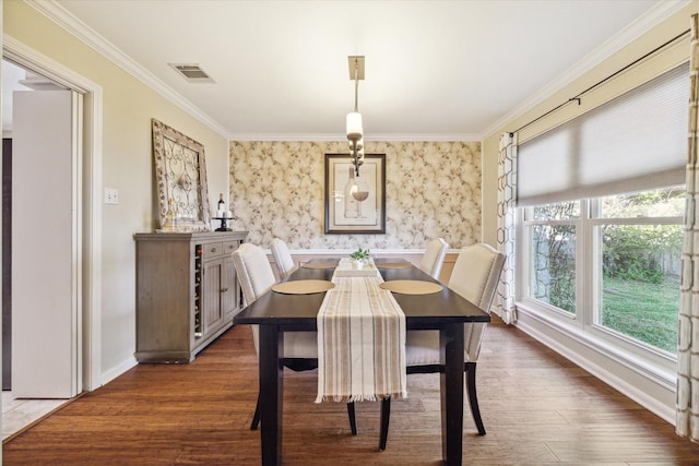 dining area featuring visible vents, ornamental molding, and wood finished floors