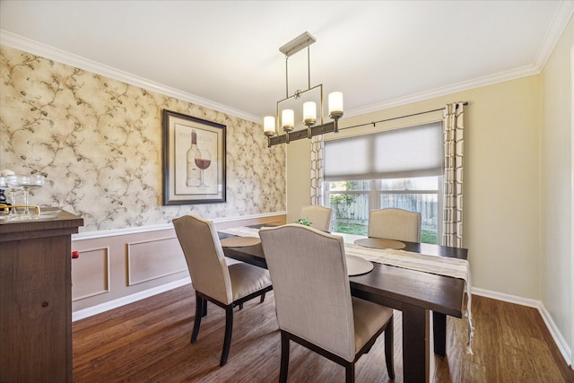 dining space with ornamental molding, a wainscoted wall, a chandelier, and wood finished floors