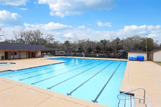 community pool featuring a patio and a hot tub